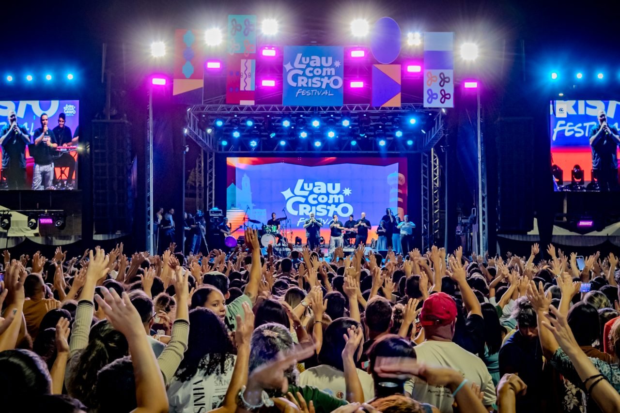 Multidão de braços erguidos diante do palco do Luau com Cristo