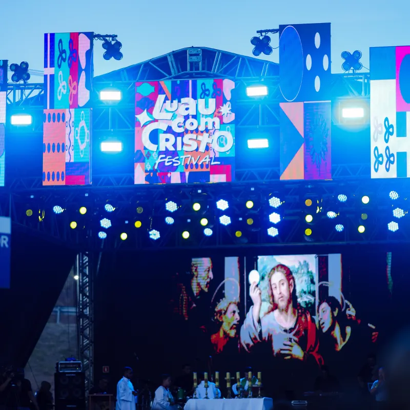 Telão do palco do Luau com Cristo Festival com a imagem de Cristo segurando a hóstia, durante a missa.